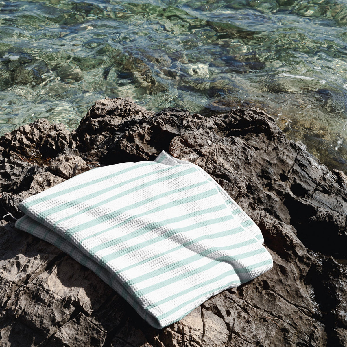 Sea Glass beach towel in blues and greens, lightweight microfiber, quick-dry, and sand-free.