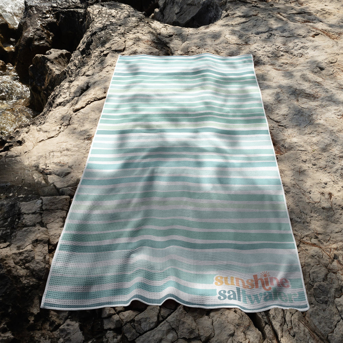 Sea Glass beach towel in blues and greens, lightweight microfiber, quick-dry, and sand-free.