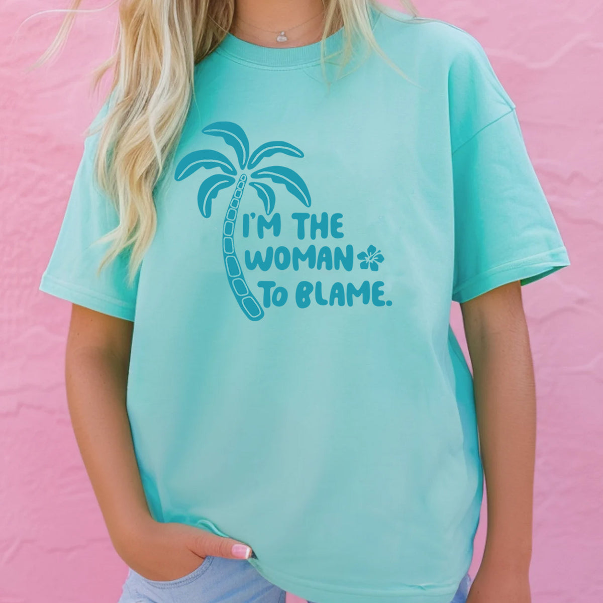 Light blue Jimmy Buffett T-shirt with &quot;i&#39;m the woman to blame&quot; lyrics written in blue next to a palm tree