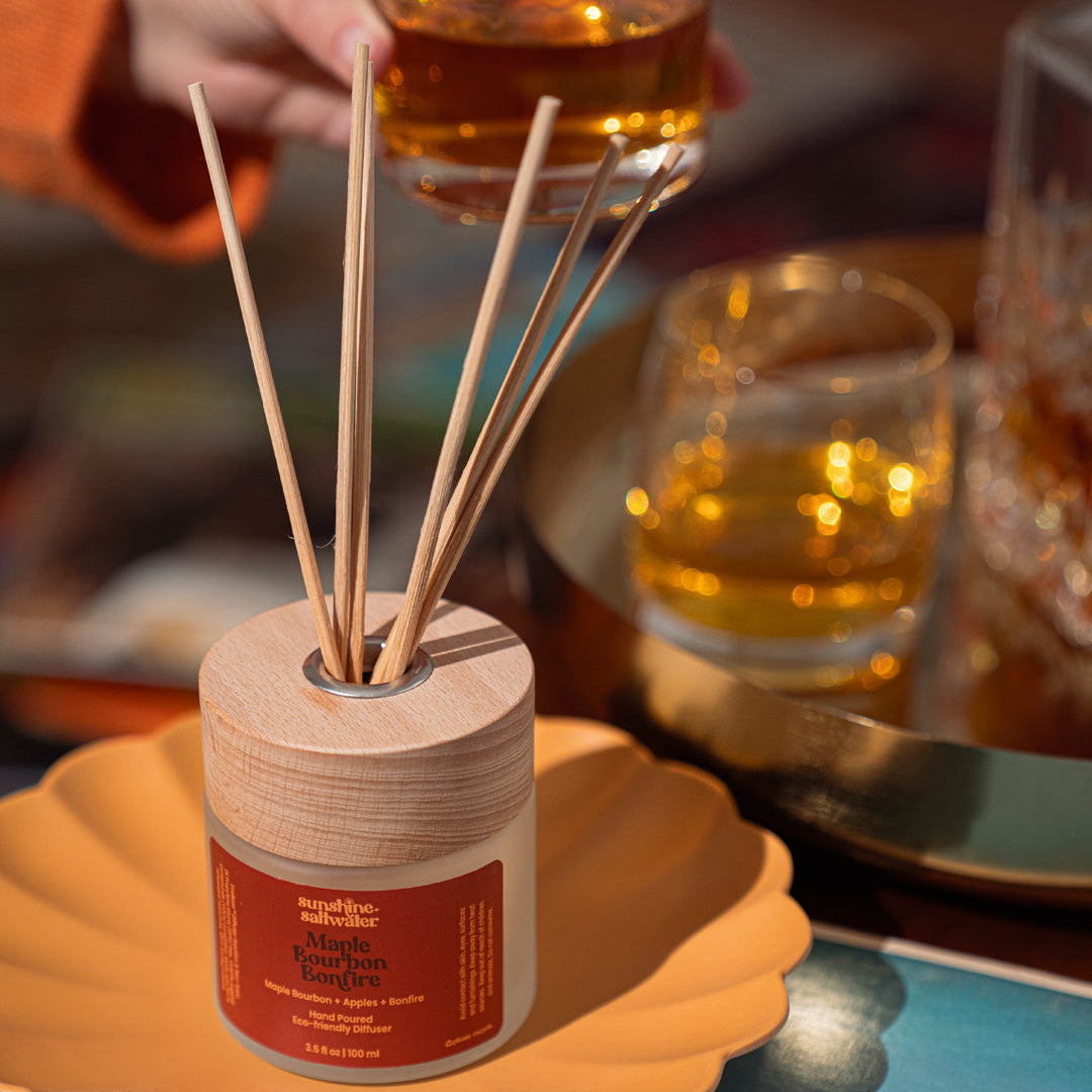 Reed diffuser with a red label on a bed of autumn leaves