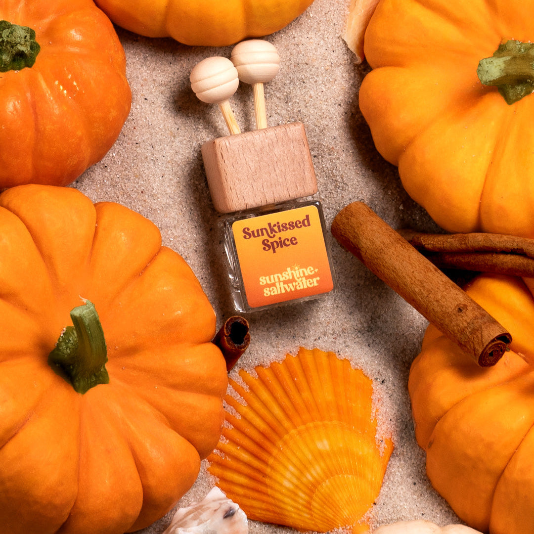 Pumpkin spice mini car diffuser with decorative elements on a textured surface