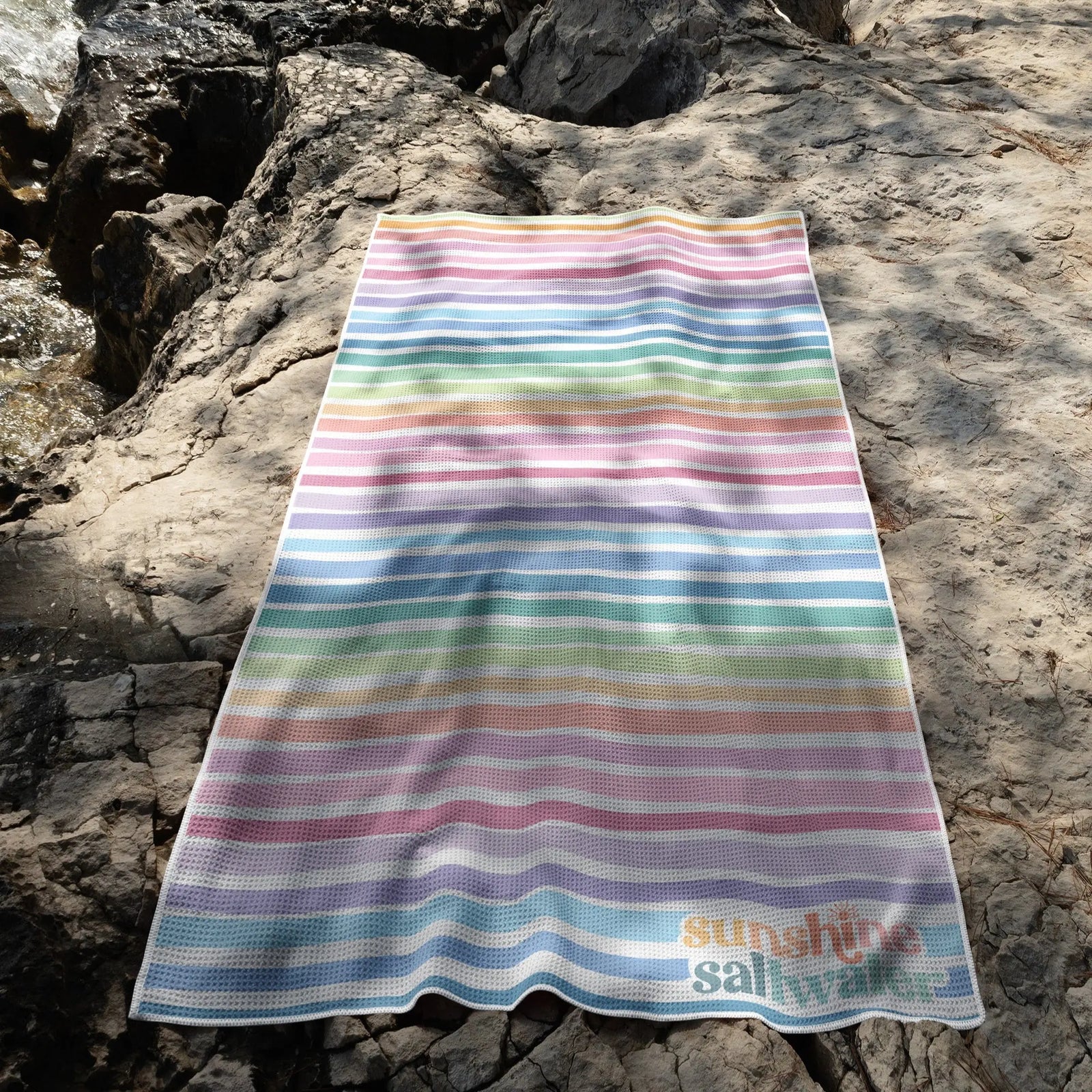 Close-up of Rainbow Reef towel’s waffle texture, featuring bold, tropical hues & a sand-resistant design