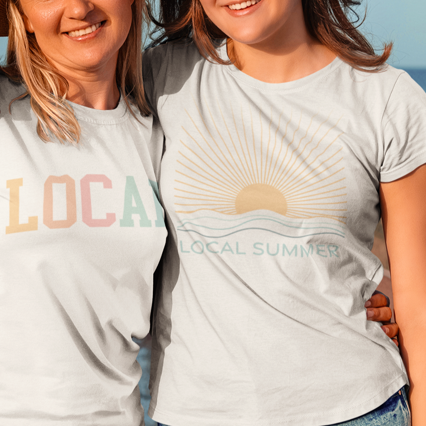 Two people wearing matching t-shirts with &#39;LOCAL&#39; text on a wooden dock by the water.