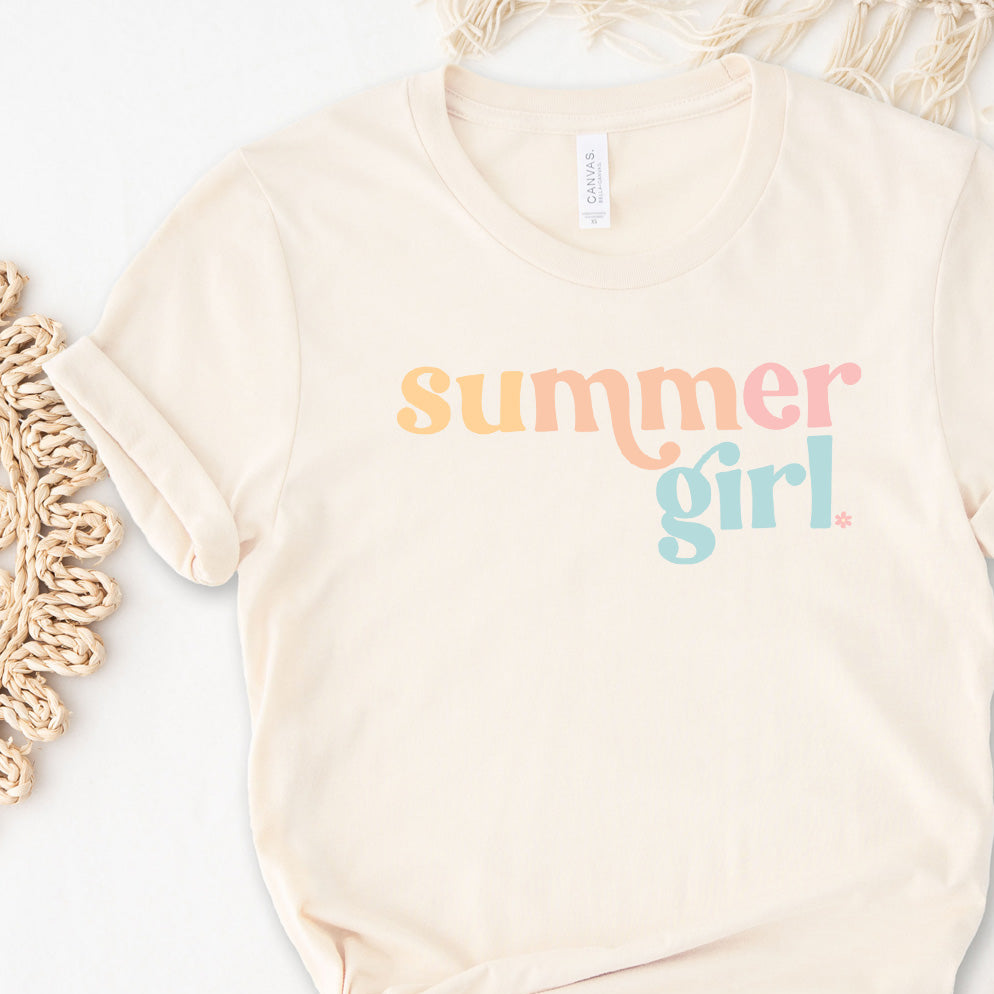 A person wearing a beige t-shirt with the text 'summer girl' in multicolored letters.